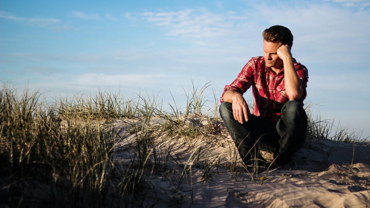 In Need of Guidance A man sitting on the beach deep in thought